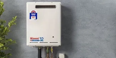 Rinnai continuous flow hot water system mounted on a wall, showcasing plumbing connections and efficiency, relevant to hot water system installation and repair services in Sydney.